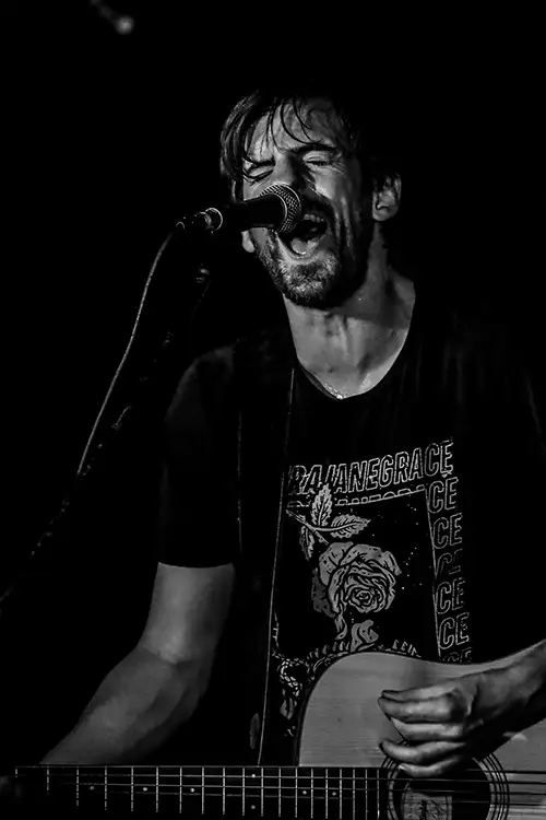 Kevin Murphy sings and plays guitar on stage